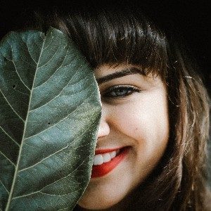 woman covering face with leaf